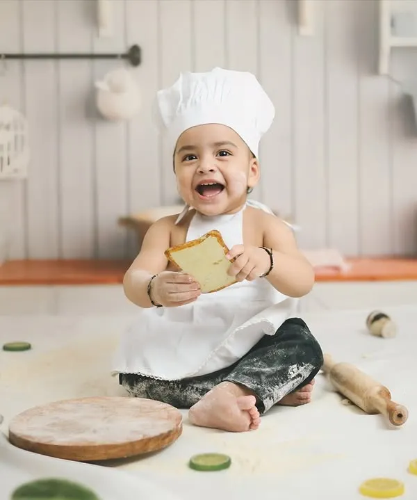 Cooking up some cuteness for a first birthday. This 'Little Chef' theme, complete with a chef's hat, apron, and a messy, flour-dusted kitchen set, is a recipe for adorable and playful photos.