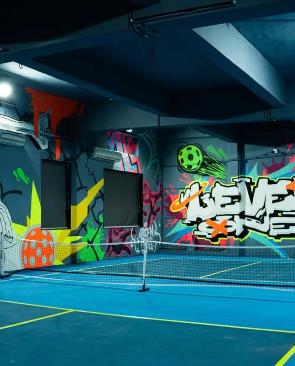 This is the Level One Arena pickleball court under normal lighting. You can see the full composition of the sports-themed graffiti, designed to be vibrant and energetic even before the blacklights are turned on.