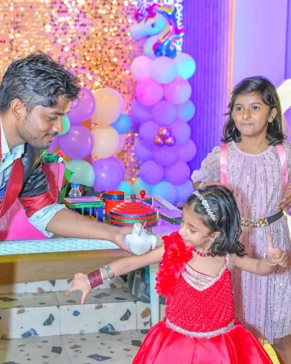 A magician captivates young guests with a live dove trick during a unicorn-themed party. A magic show is a fantastic add-on to keep everyone entertained.