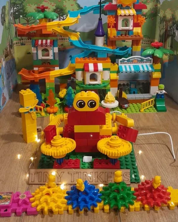 A colorful and interactive amusement park model built by our 'Tiny Tinkers' team using LEGO Discover kits, demonstrating their understanding of gears and simple machines.