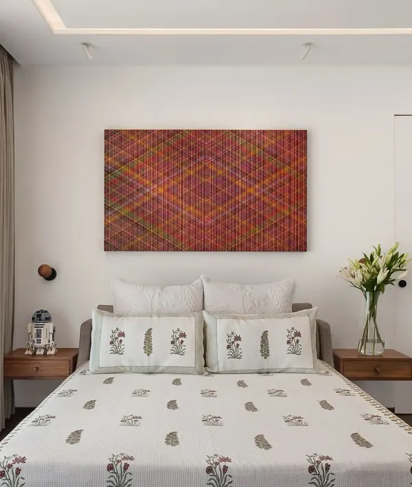 In the West Coast Residence, this bedroom is a serene space defined by clean lines and personal touches. The floating wooden nightstands and minimalist wall sconces keep the design uncluttered, while the client's own collectibles add a unique character.