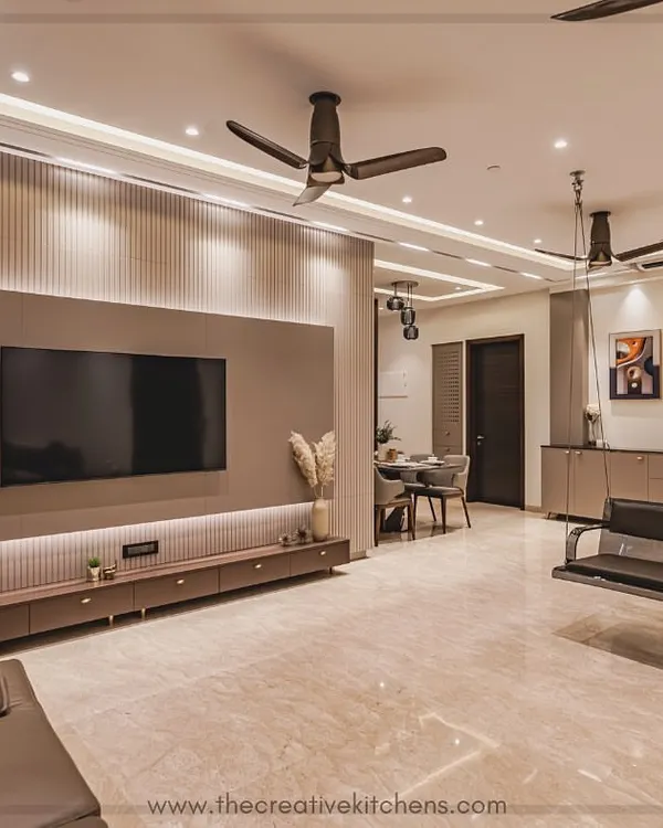 This living room is a serene escape, featuring a bespoke modular TV unit in a PU finish and a caffeinated color palette. The floating console and fluted back panel create a minimalist yet warm focal point for the entire space.