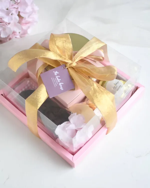 My grand Rakhi Hamper, packed with an assortment of goodies including brownies, cookies, and a Baklava tea cake, all tied up with a beautiful gold ribbon.