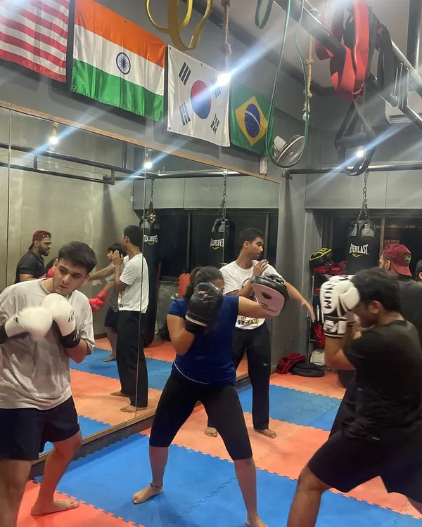 The gym is buzzing during a group session. Everyone is paired up, working on boxing drills and pushing each other to get better with every round.