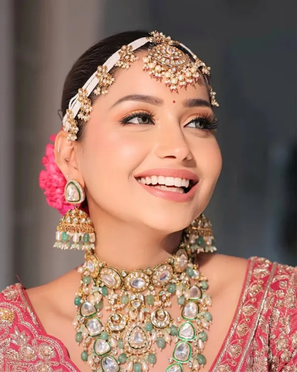 This is the smile I work for. For this bride, we focused on creating a soft, peachy shimmer on the eyes and a flawless, radiant skin finish that looks beautiful in photos and feels comfortable all day. The nude-matte lip color perfectly complements her stunning bridal jewelry and red lehenga.