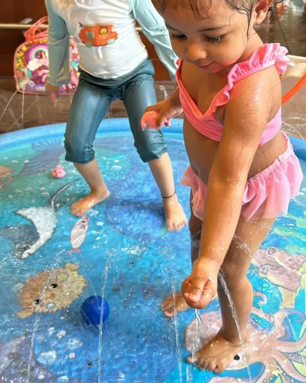 This little one is enjoying the gentle sprinklers in our splash pad. It's a perfect sensory activity for toddlers, especially on a warm day.