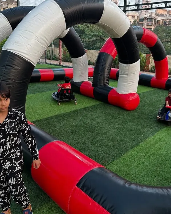 Kids racing on my inflatable go-kart track. I set up the entire circuit on grass for safe, high-speed birthday party fun.