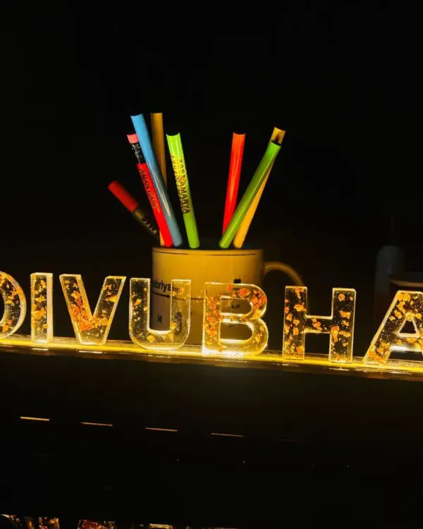 This custom LED name lamp is a stunning addition to any desk or room. The light shines through the acrylic letters, which are filled with gold flakes for an extra sparkle.
