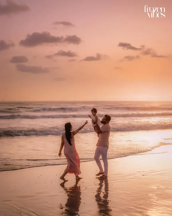 A family plays on the shore as the sun sets, painting the sky in warm golden hues. This is the magic of a golden hour family session, where we capture pure, uninhibited joy against the beautiful backdrop of the ocean.