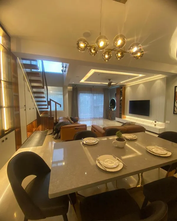 An open-plan living and dining area creates a sense of spaciousness. I used a statement chandelier and recessed ceiling lights to define the dining space while keeping it connected to the living room.