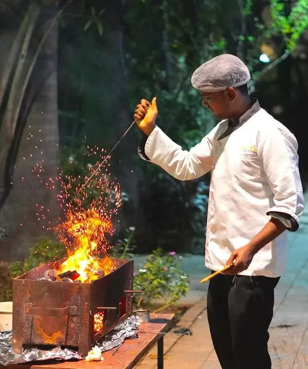 The sight and sound of a live tandoor station adds an authentic and exciting element to any wedding. My chef is seen here expertly grilling starters over open flames, ensuring every piece is served hot, smoky, and full of flavor.