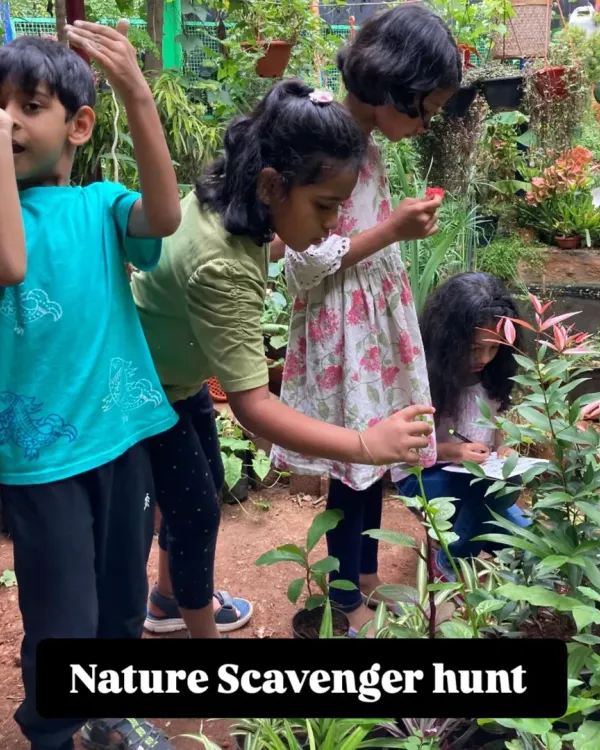 Young explorers on a mission during our Nature Explorer Camp. A scavenger hunt in a lush garden setting encourages them to look closely at plants and search for tiny creatures, honing their observation skills.