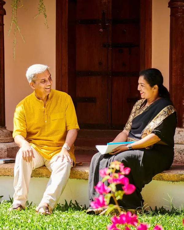 Two of our senior Ayurvedic doctors in conversation on the veranda of a heritage cottage. Their deep knowledge and compassionate approach guide your entire healing journey.