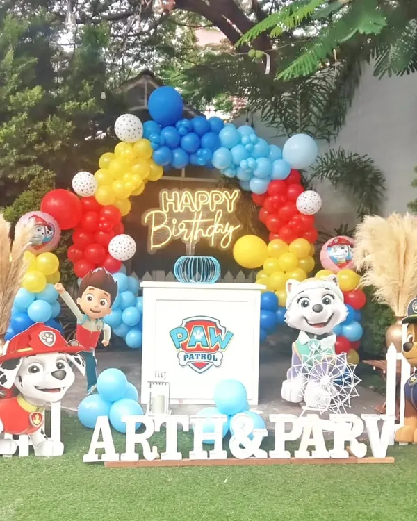 A fun-filled Paw Patrol birthday party theme. This setup includes a colorful balloon arch, character cutouts of the popular pups, and a personalized name display for the birthday kids.