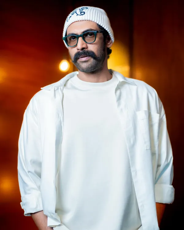 Styling Rana Daggubati in an all-white look for the brand Kingdom of White. This close-up shows the layering of a t-shirt and an open shirt, creating texture and depth within a single color.