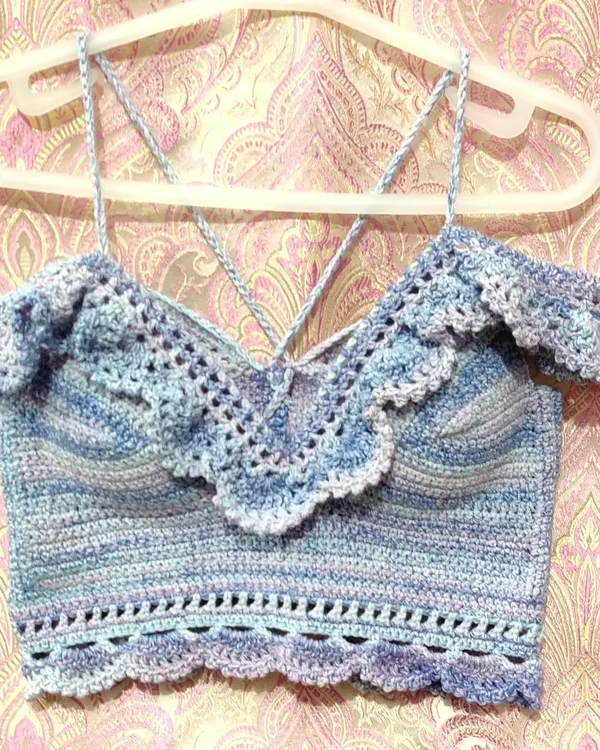 A custom-made 'Masakali' bralette top in a beautiful blue-purple variegated yarn. It features delicate lace details, off-the-shoulder ruffles, and adjustable straps for a perfect, comfortable fit.