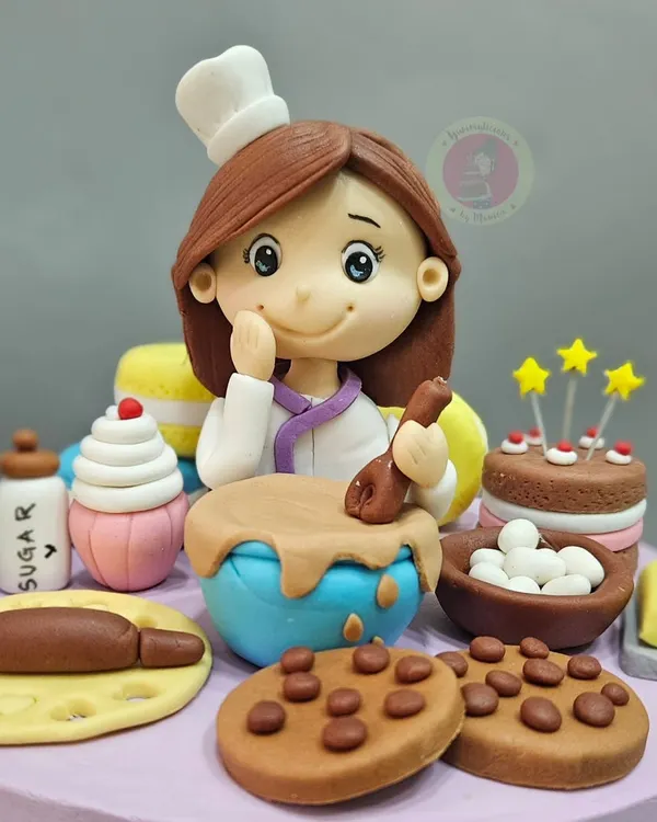 A close-up of a baker-themed cake topper. We often get requests for similar themes, and I love creating these cute, detailed scenes that celebrate a fellow baker's passion.