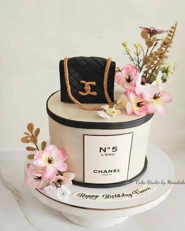 What's not to love about this Chanel themed cake? It features the iconic No. 5 logo and is topped with a handcrafted, quilted Chanel bag and beautiful flowers.