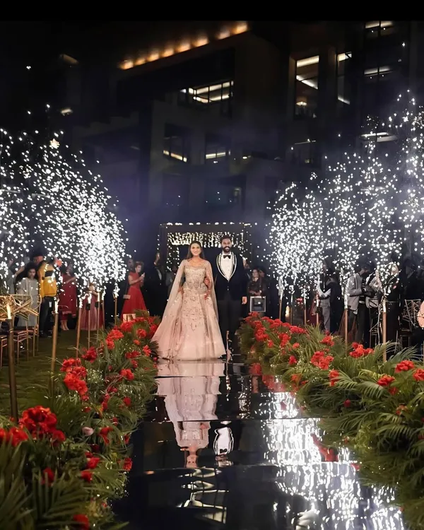 For a truly glamorous entrance, I create stunning mirror-paved aisles flanked by trees lit up with cold pyrotechnics. This setup provides a spectacular reflection and a path of light for the couple's grand entry.