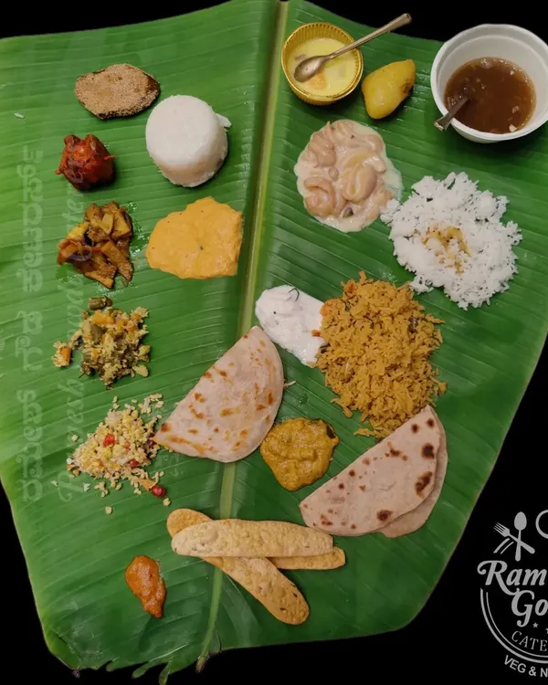 A complete vegetarian oota served on a fresh banana leaf. This meal includes a variety of palyas, kosambari, chapati, rice, sambar, and sweets, offering a full traditional experience.
