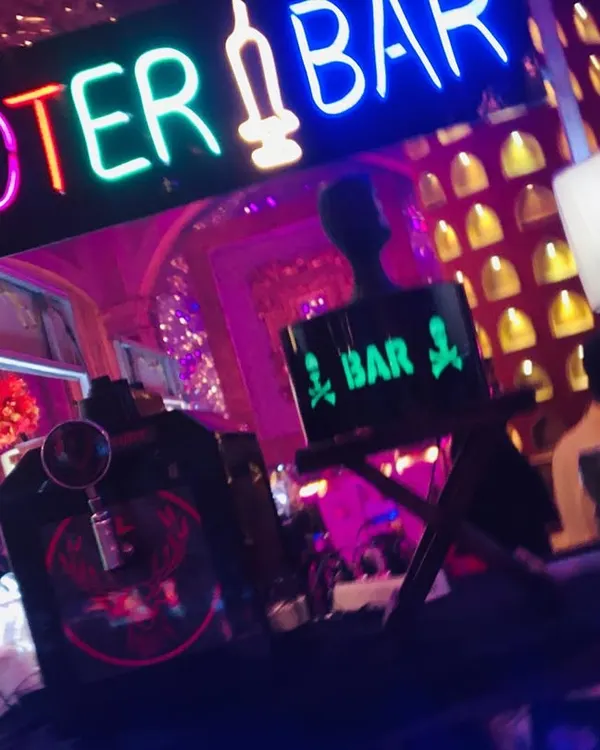 My 'Shooter Bar' is designed to be the life of the party. This setup features a bold, colorful neon sign, a Jägermeister tap machine, and unique decor for a fun vibe.