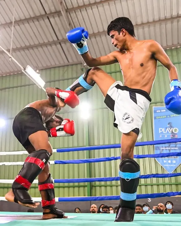 We believe in testing our skills at the highest level. Here you see one of our black belt coaches, Vinod, executing a precise high kick during a competitive kickboxing bout. This level of technical skill and composure under pressure is what we instill in all our students.