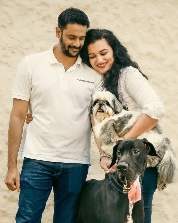 A beautiful family portrait where a gentle Great Dane and a spunky Shih Tzu complete the picture. This is a perfect example of a 'big meets small' story, capturing the love that makes a house a home.