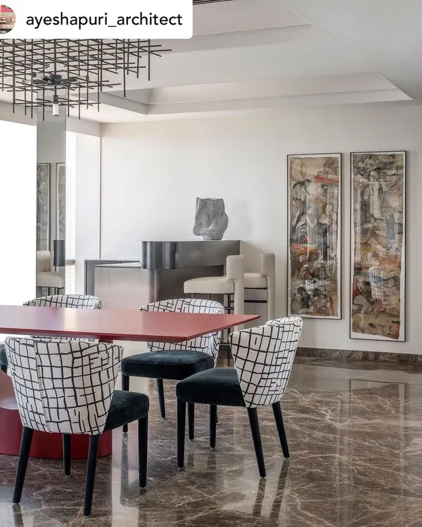 For this playful dining area, we paired a bold red metal dining table with chairs upholstered in a custom black-and-white print. The entire setting is designed to feel like a playground for art and color.