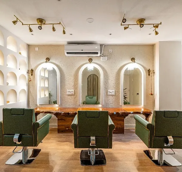 This is the main salon area of the Vedic Spa, designed to be a sanctuary of calm and luxury. I used a combination of live-edge wood, arched mirrors with integrated lighting, and comfortable olive green chairs to create a space that feels both organic and upscale, ensuring every client feels pampered.
