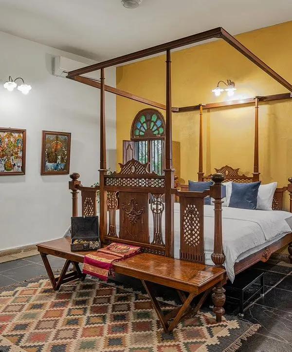 The Arundati suite, with its warm yellow walls and antique four-poster bed, offers a cheerful yet regal setting for your stay or photoshoot.