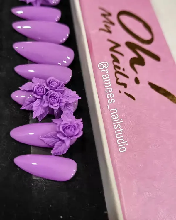 An example of a custom press-on nail set. This beautiful lilac design features two accent nails with incredibly detailed, hand-sculpted 3D rose bouquets.