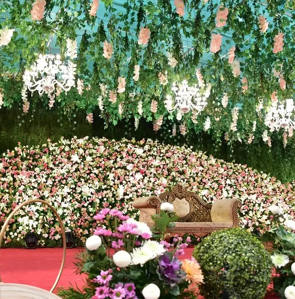 A closer look at the immense floral stage we created for a wedding reception. The sheer volume of flowers and the hanging floral ceiling with chandeliers made the entire venue feel like an enchanted garden.