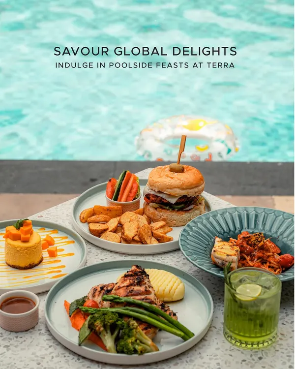 We invite you to indulge in a feast for the senses at Terra, our poolside dining space. This vibrant spread captures the essence of our global culinary offerings, from hearty burgers and fresh pasta to grilled chicken and delicate desserts, all enjoyed with the tranquil backdrop of our shimmering pool.