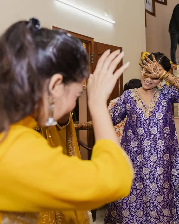 A candid moment from a Mehendi function. The bride, a Telugu woman from Vishakhapatnam, chose to wear a vibrant purple Banarasi kurta with bandhani pants, a beautiful fusion of cultures that we curated virtually.