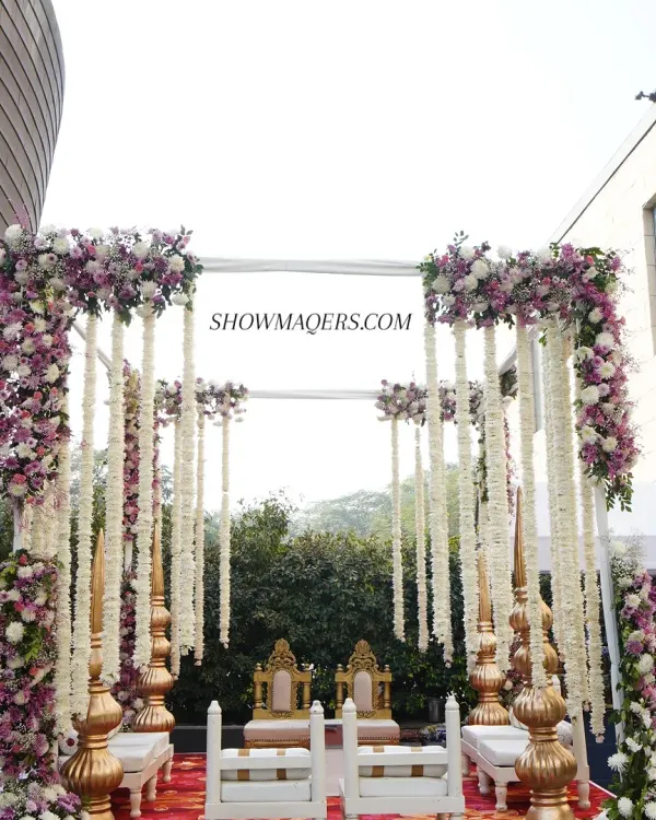 A beautiful day wedding mandap at The Westin, featuring lush purple and white floral arrangements with hanging jasmine garlands. The design combines traditional elements with a fresh, modern aesthetic for an elegant outdoor ceremony.