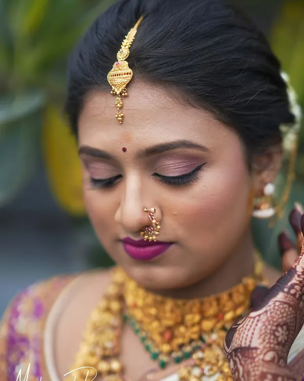 A close-up of Pooja's wedding makeup. The soft pink eyeshadow and bold magenta lip perfectly complement her traditional attire, creating a fresh and vibrant bridal look.