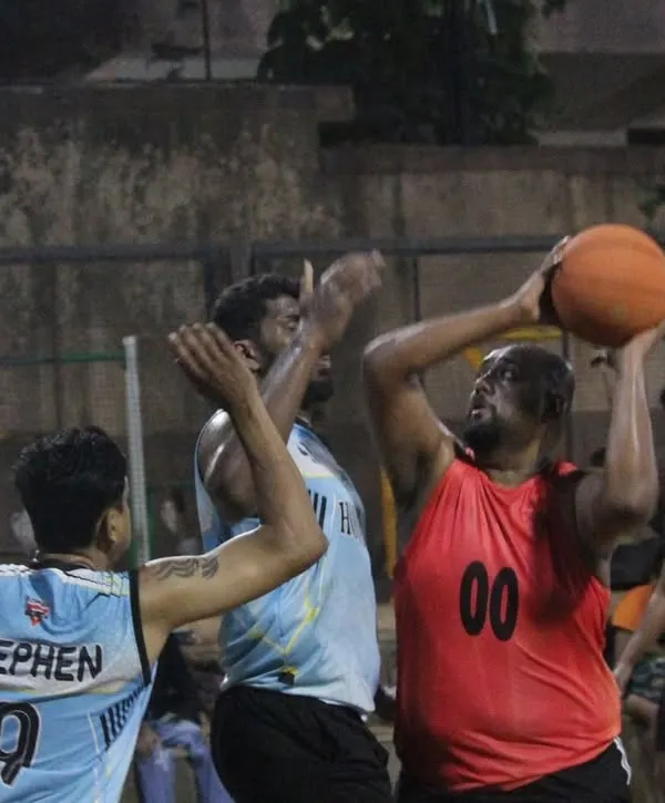 A player goes up for a tough shot in the paint, surrounded by defenders. This is the grit and determination we see in every game.