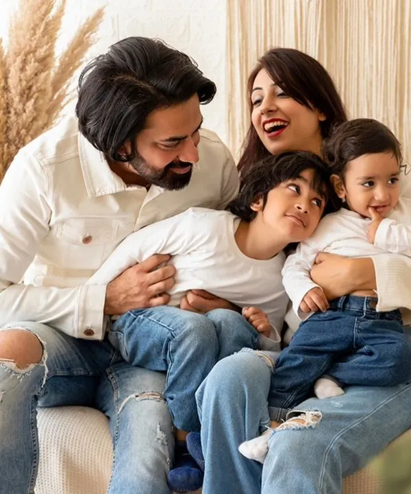A candid and joyful family portrait session in my studio. I focus on capturing real laughter and playful interactions, like this moment with the whole family together on the couch.