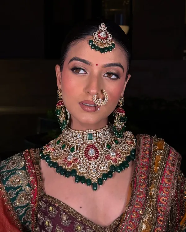 This is the moment we work for. A complete bridal look, where the jewellery, the outfit, and the bride's glow come together perfectly. This stunning Polki and emerald choker set is designed to make you feel nothing less than royal on your big day.