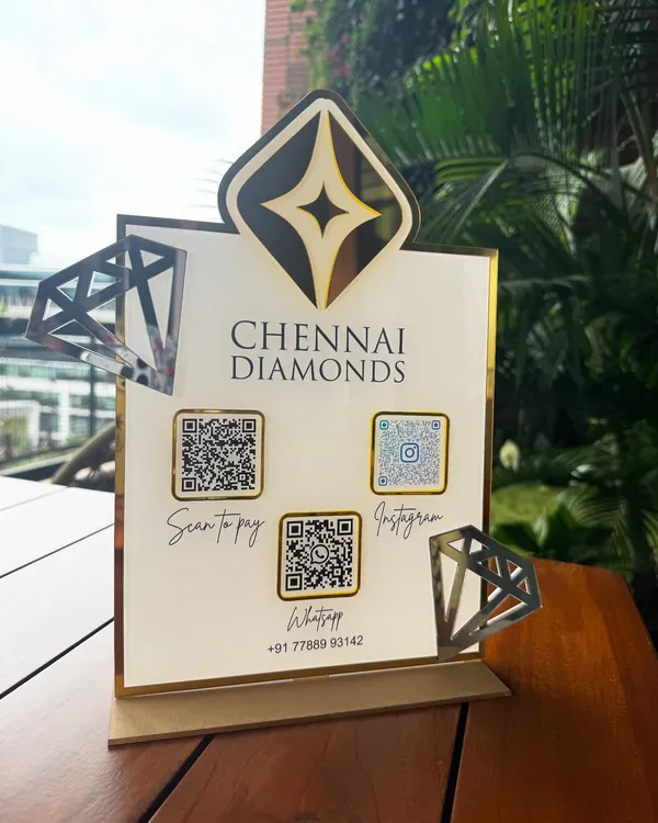 A look at the elegant, custom-designed QR code stand we created for Chennai Diamonds. This piece features their logo prominently with a gold mirror finish, diamond-shaped accents, and clear QR codes for payments, Instagram, and WhatsApp, all on a stable, professional display.