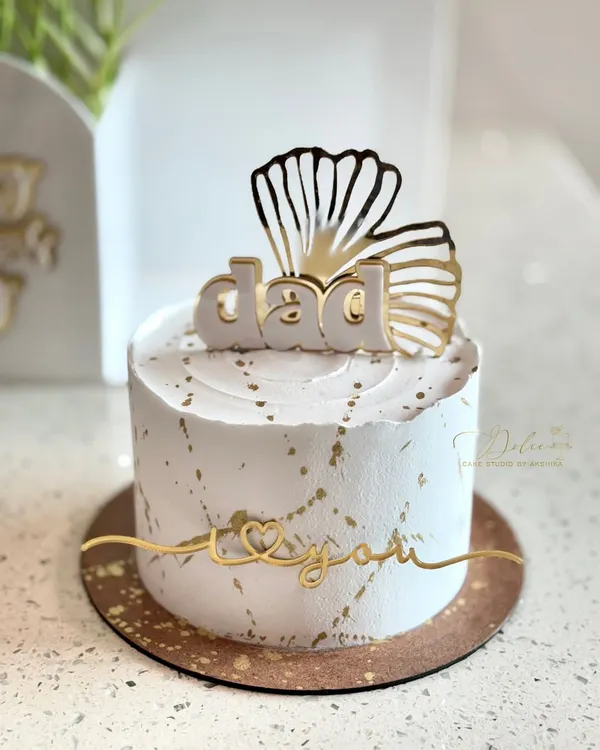 A classic and elegant cake for Father's Day. This half-kg cake features clean white frosting with gold splatter, topped with a 'Dad' acrylic topper. It's a simple yet beautiful way to show your love.