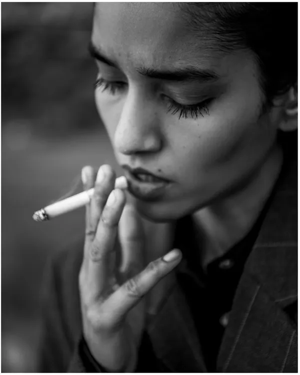 An intimate black and white close-up that feels like a still from a classic film. The lighting is soft and moody, focusing on the model's expression.