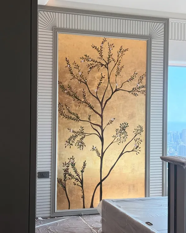 This gold leaf tree mural, set within a custom wall panel, is one of my favorite ways to bring a sense of peace and luxury into a bedroom. The metallic sheen catches the light differently throughout the day, making the wall feel alive.