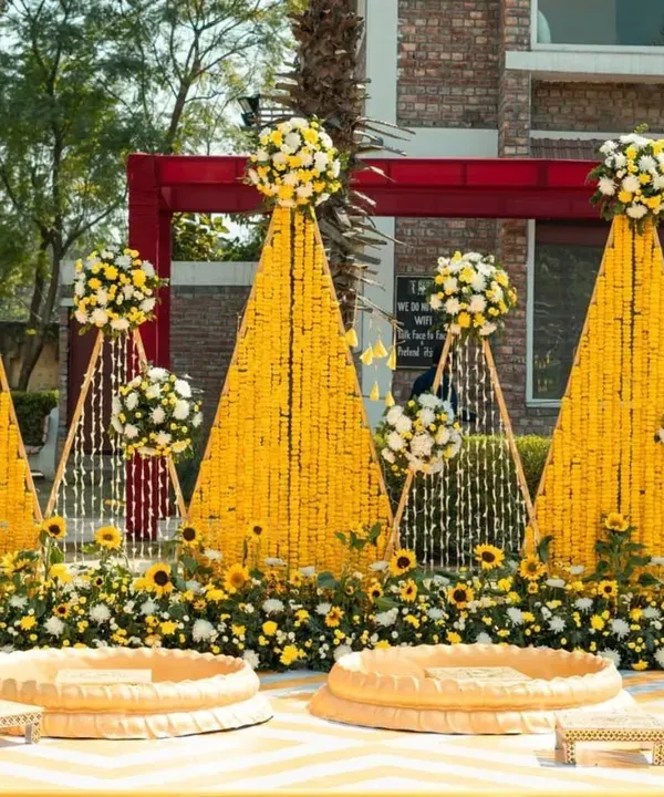 A beautiful Haldi setup featuring cones of marigold flowers and sunflower accents. This design is perfect for outdoor ceremonies, creating a bright and cheerful space for your pre-wedding functions.