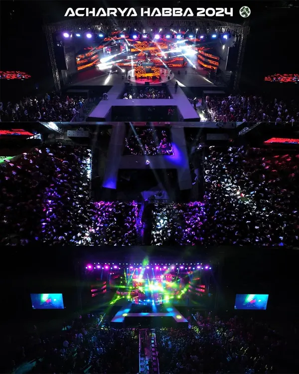 An aerial top-down shot capturing the immense crowd and spectacular stage lighting at Acharya Habba 2024. This perspective, only possible with professional drone videography, shows the sheer scale of the event and the energy of the audience.
