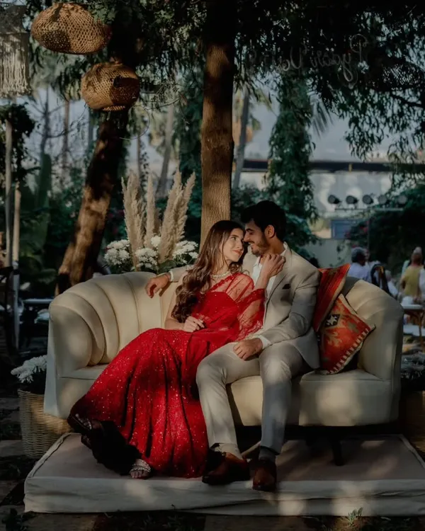 Capturing a quiet moment amidst the celebration. We designed this cozy seating area for the happy couple against a backdrop of lush greenery and bohemian decor, perfect for timeless engagement photos.