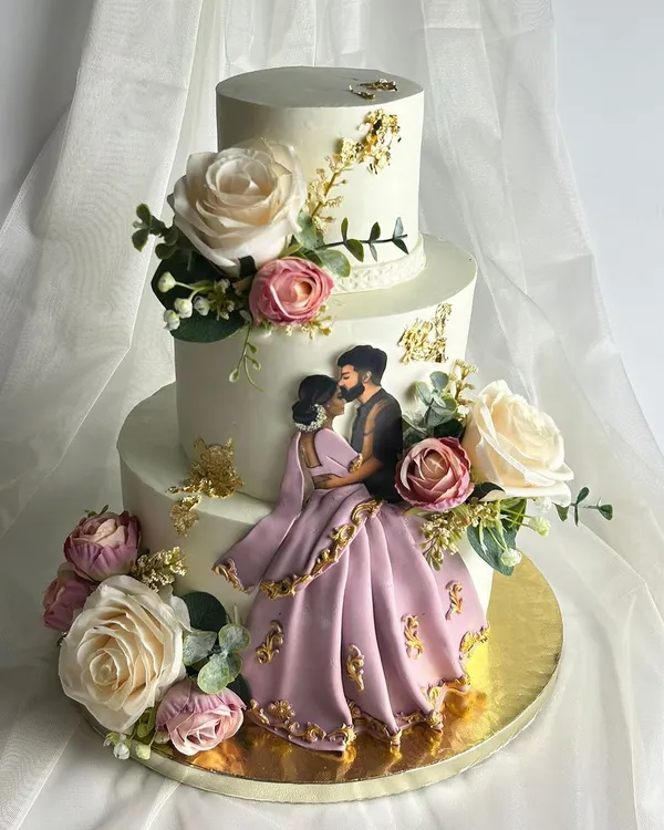This three-tier masterpiece was designed for a beautiful Valima ceremony. I worked with the couple to create a design that reflected their love story, finishing the whipped cream cake with a hand-painted edible illustration of them and floral arrangements matching the bride's dress.