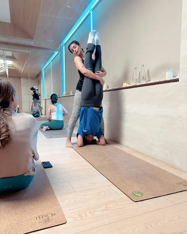 In my workshops, I provide hands on support to help you understand the alignment and feel of a pose. Here, I'm assisting a student with her sirsasana (headstand), ensuring she feels secure as she builds strength and confidence in her inversion practice.