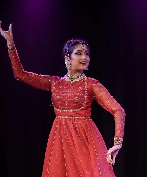 A solo moment on stage during a Kathak performance. This portrait captures the elegance of the costume and the expressive hand gestures, or mudras, used in storytelling.