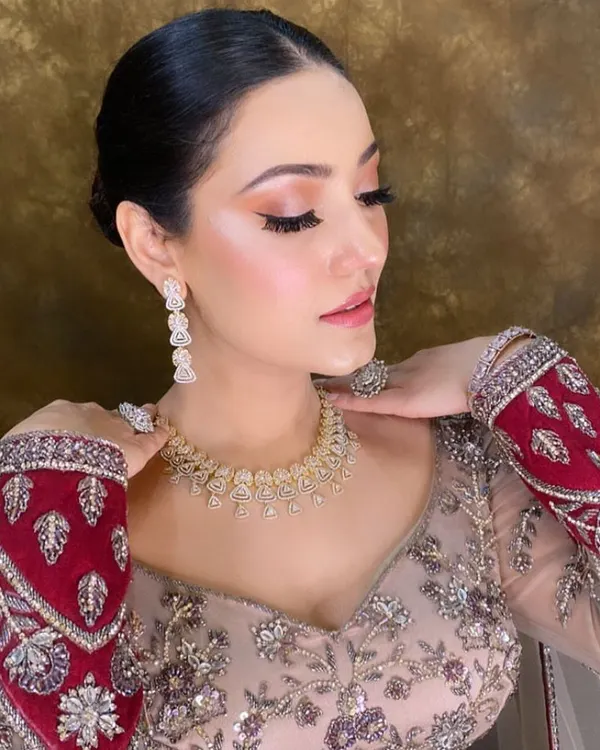 A classic bridal look featuring a clean, low bun and radiant HD makeup. This timeless combination is perfect for the bride who wants an elegant and sophisticated style on her wedding day.